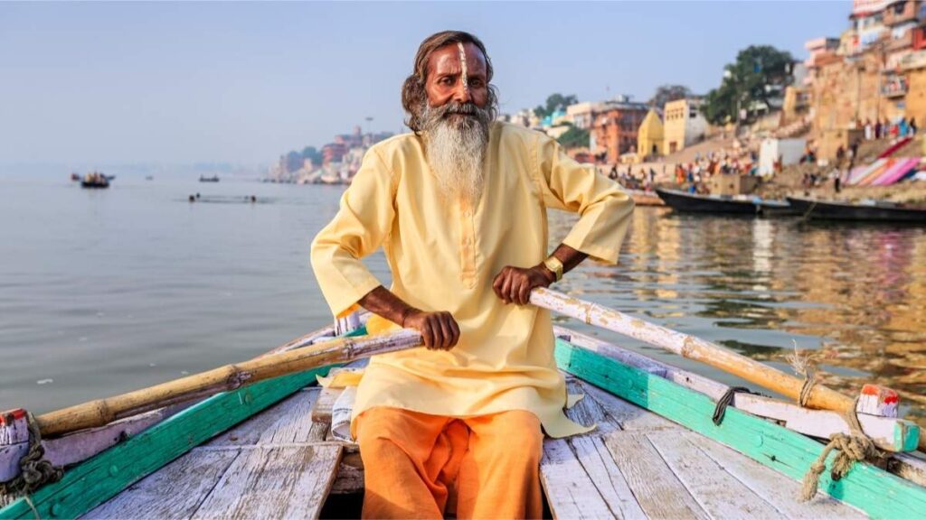 A Hindu sadhu boating in the Ganges River of Varanasi, India,