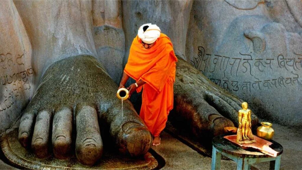 The Jain priest was cleaning the feet of this colossal monolithic statue of Lord Bahubali